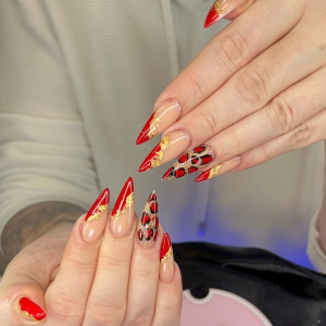 winternails-2025-elegante-rote-stiletto-ngel-mit-gold-leopardenmuster-das-trenddesign-bei-ruby-nails-rostock
